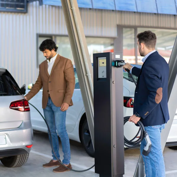 Duas pessoas a carregar os seus carros elétricos num posto Pole Pro
