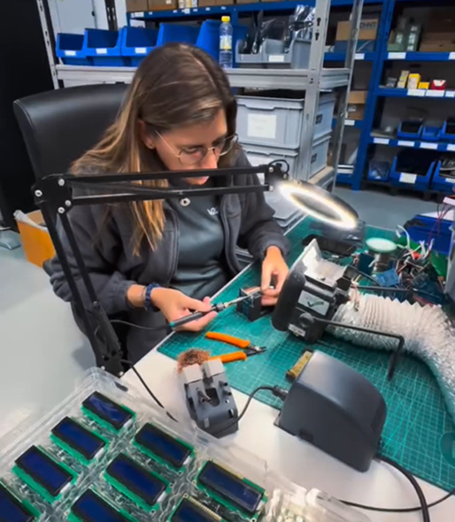 Ingeniera de V2C revisando la placa electrónica de un cargador