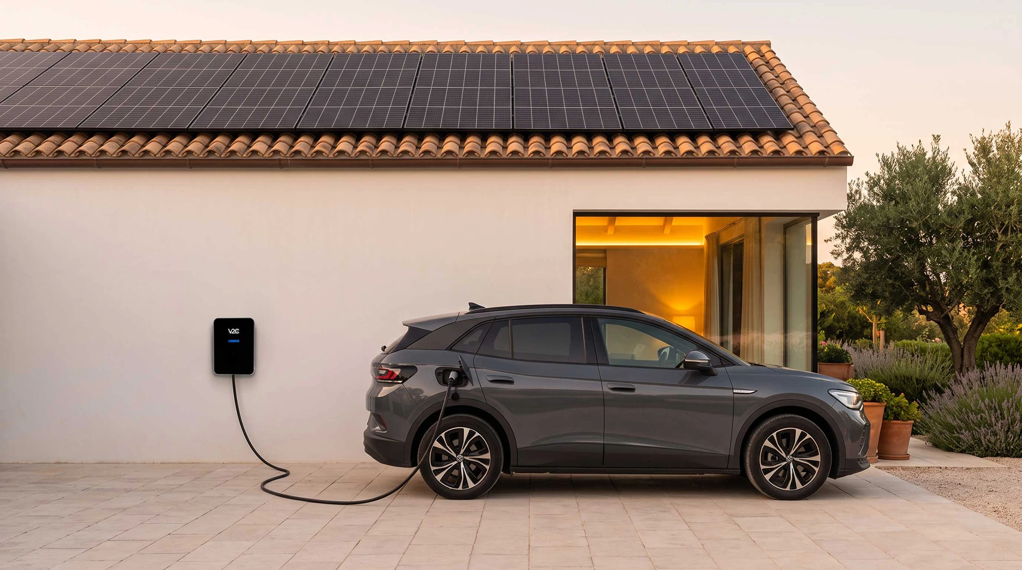 Trydan electric car charger on a white wall of a house with solar panels on the roof, car charging at sunset beside a warm lit window